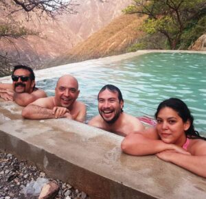 Group of friends in a pool near mountains